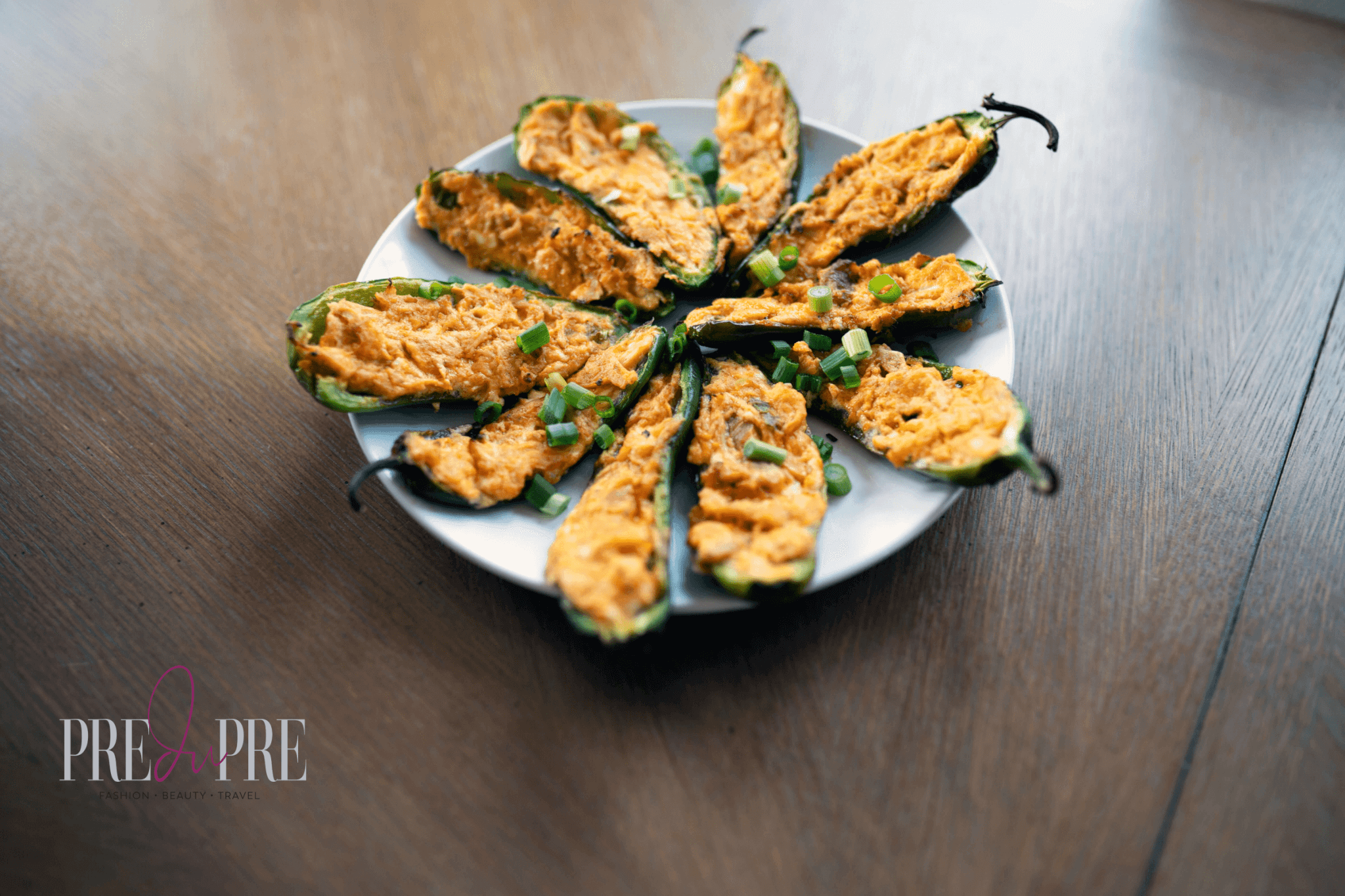 stuffed jalapeno buffal chicken poppers displayed on round white plate