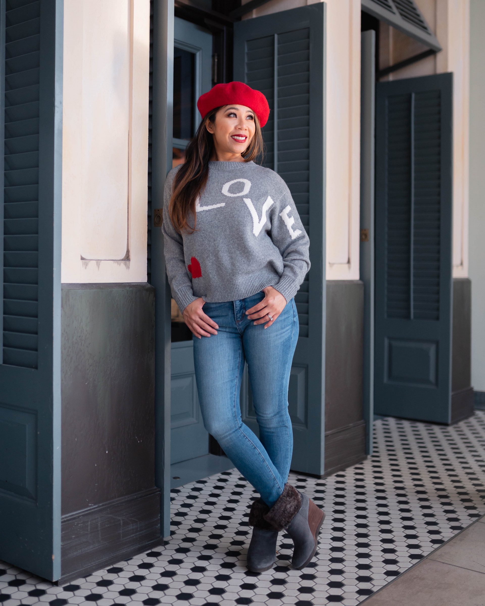 lady wearing a gray valentine's sweater with the word LOVE spelled out