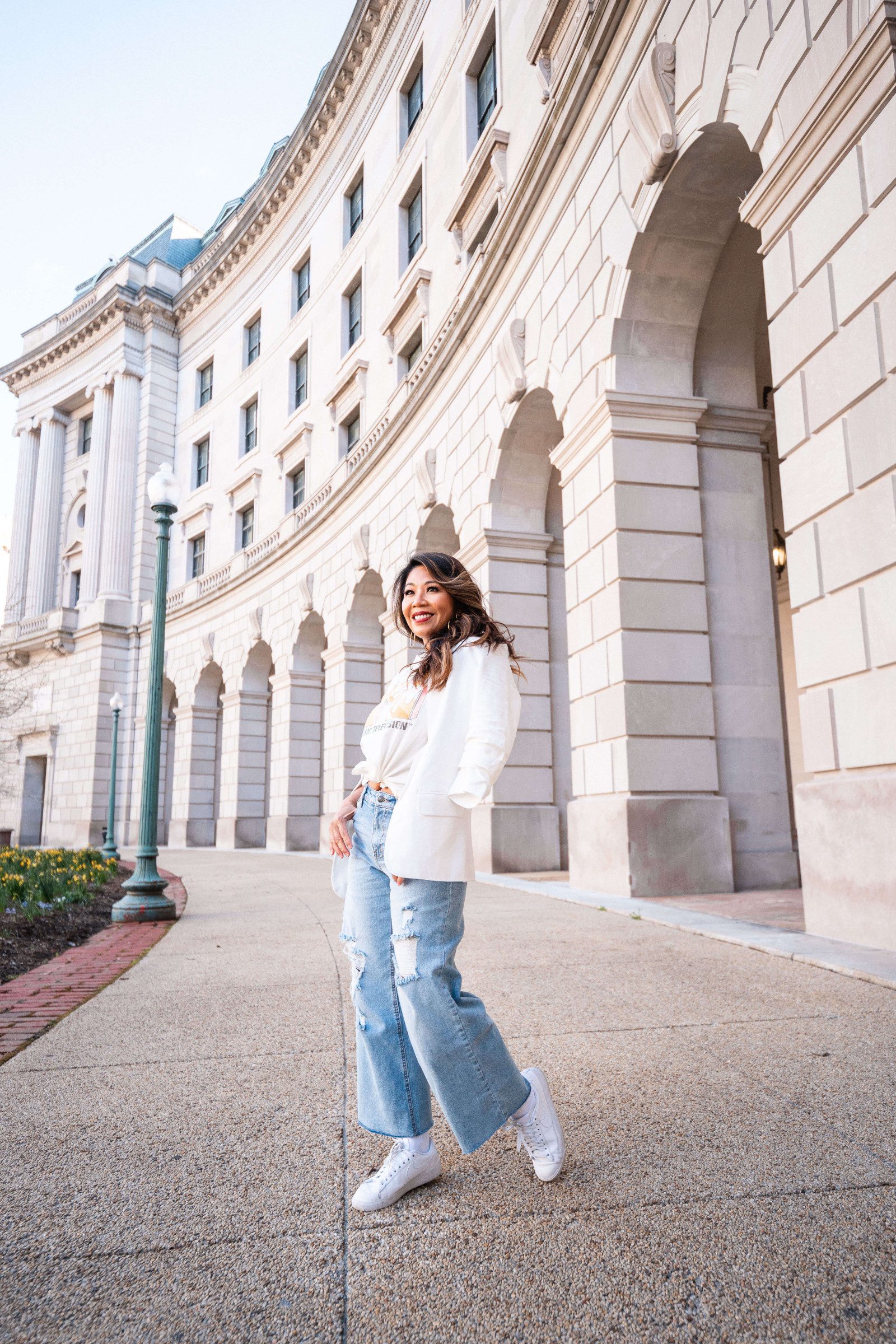 Predupre wearing a tshirt with white blazer on top with denim and sneakers.